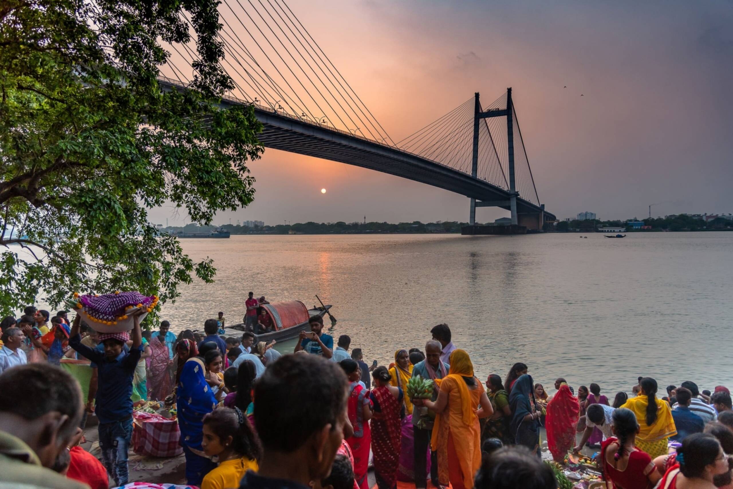 Indian Devotees at Prinsep Ghat, Worshipping the Ganges River against the Backdrop of the Illuminated Vidyasagar Setu