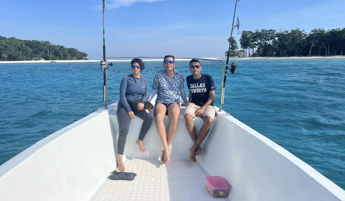 A Chartered Fishing Boat from Port Blair (BiteMe Charters) with tourists enjoying a leisurely sail just off the shore of North Cinque Island's iconic tombolo.