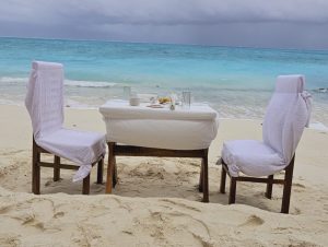 SetMyTrip 4 Nights Lakshadweep Agatti Beach Resort Stay Package (Honeymoon Special)– includes a private beach celebration set-up with an intimate dining table arranged on the white sands of Agatti Island, offering couples a romantic daytime experience by the turquoise sea.