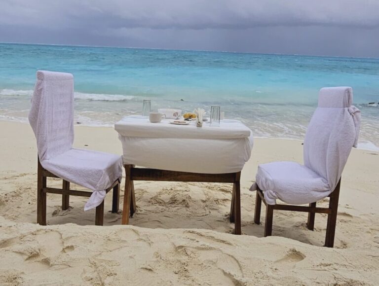 SetMyTrip 4 Nights Lakshadweep Agatti Beach Resort Stay Package (Honeymoon Special)– includes a private beach celebration set-up with an intimate dining table arranged on the white sands of Agatti Island, offering couples a romantic daytime experience by the turquoise sea.