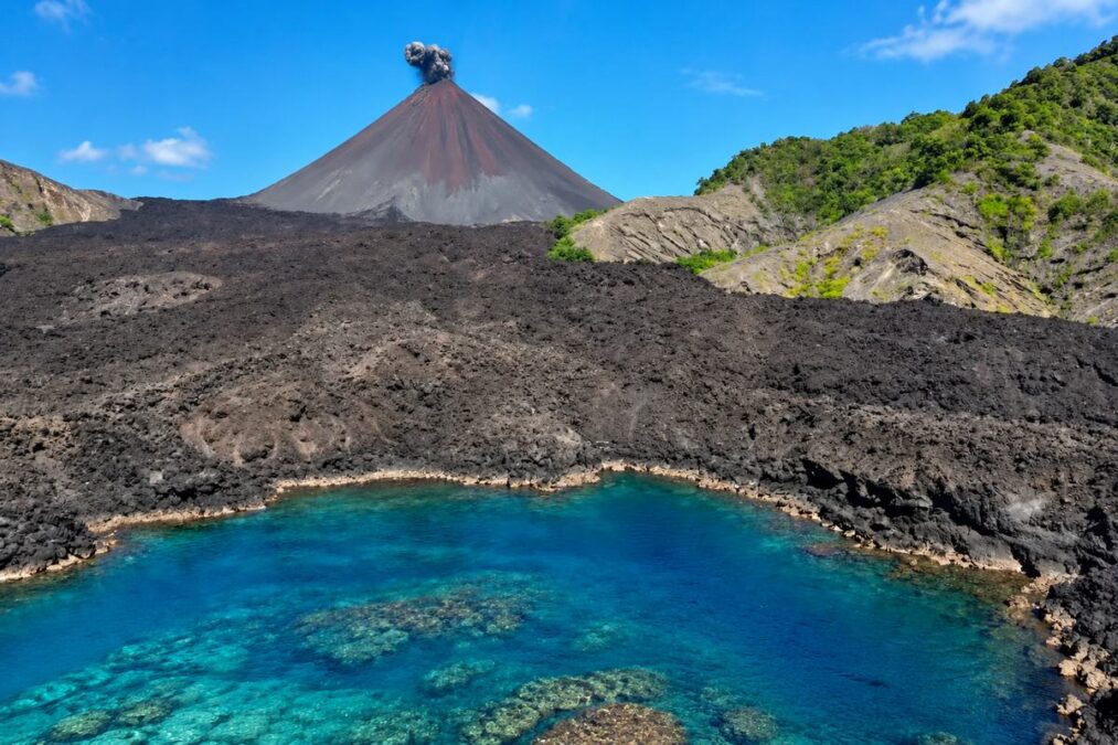 Barren Island active volcano with black lava fields and turquoise sea in the Andaman Islands