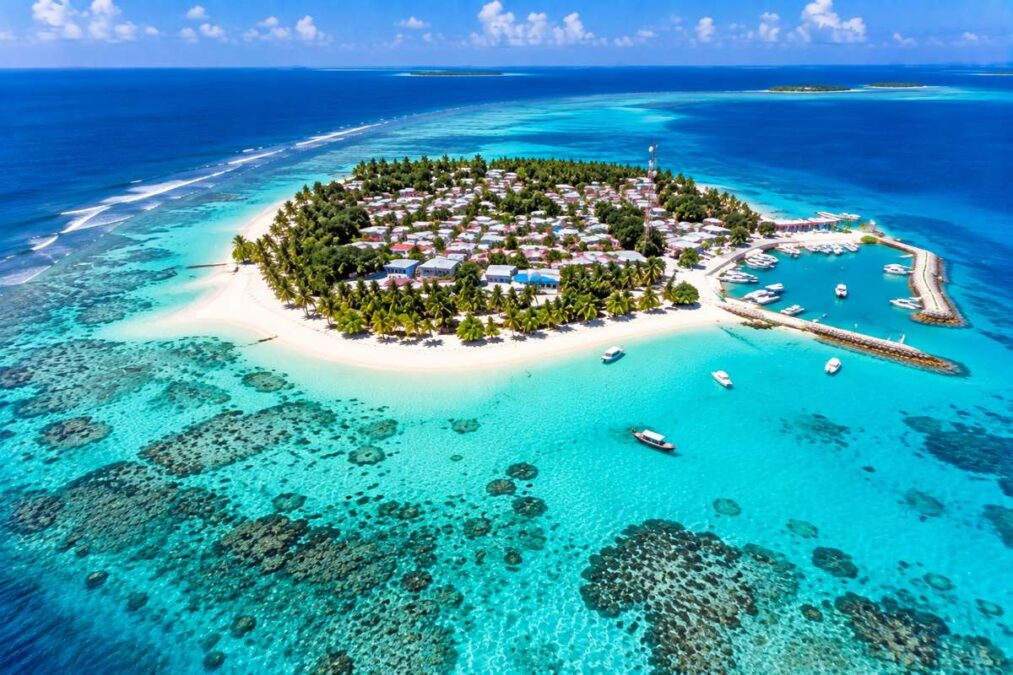 Aerial view of Dhiffushi Island Maldives with village, harbour, coral reef and turquoise lagoon